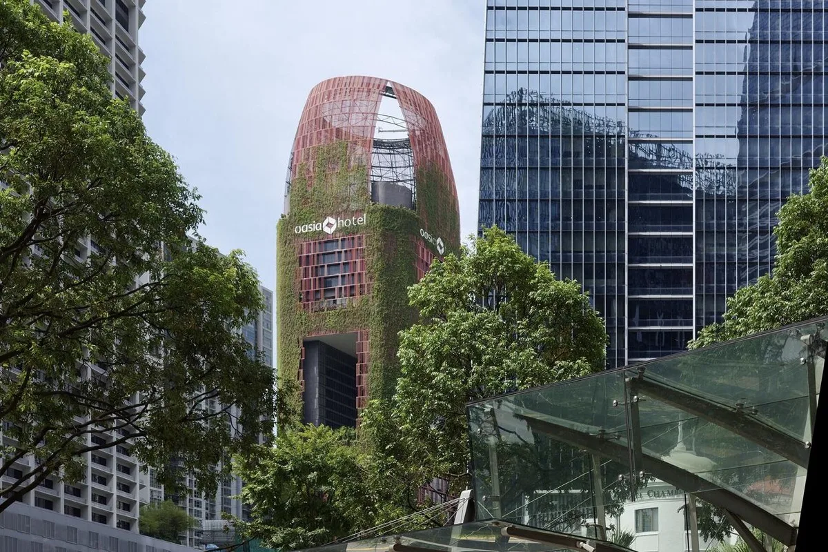 Oasia Hotel Downtown, its red aluminium mesh facade grown through with creepers